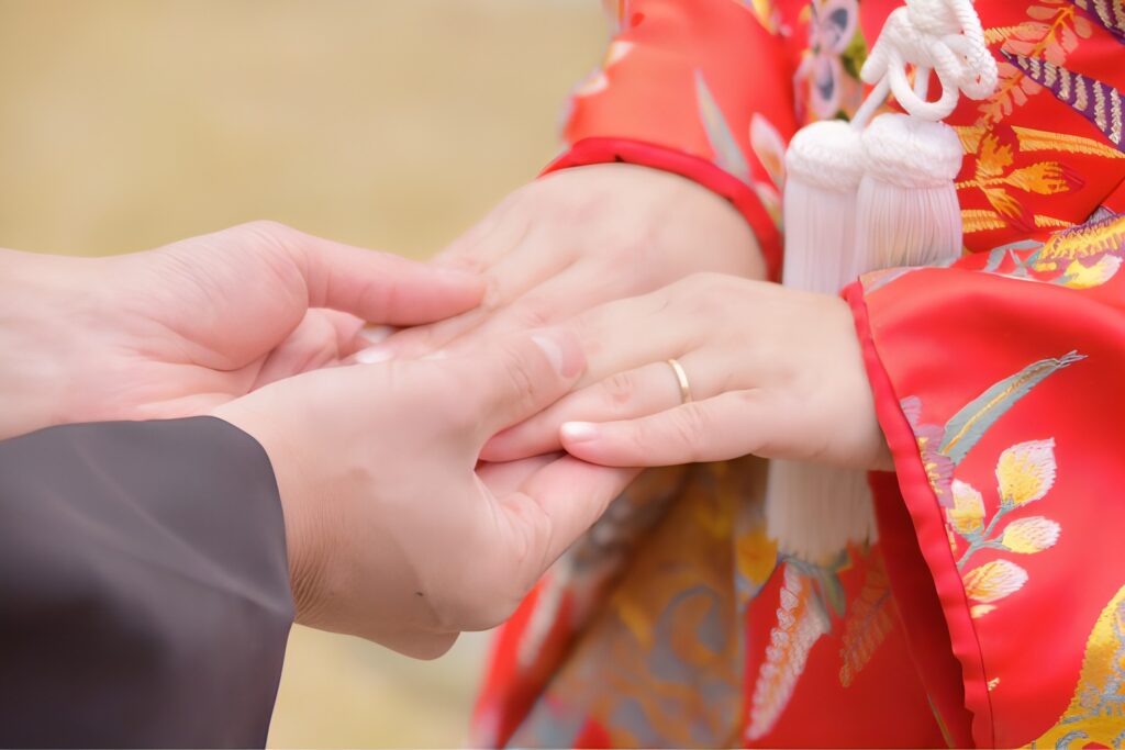 松村と中国人妻のナナが手を取り合う様子